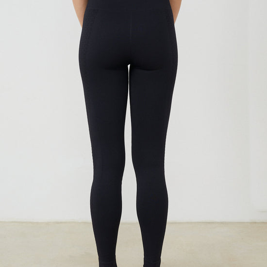 Vista trasera malla yoga larga mujer marca NOY (not only yoga) modelo GAIA sin costuras tono negro black lava