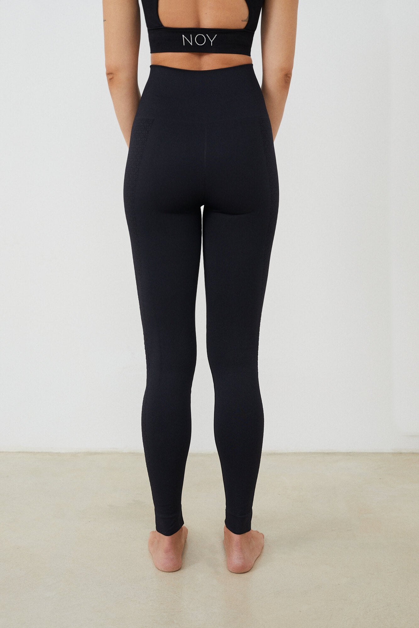 Vista trasera malla yoga larga mujer marca NOY (not only yoga) modelo GAIA sin costuras tono negro black lava