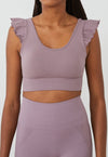 Vista frontal top yoga mujer marca NOY (not only yoga) modelo AINE con volantes tono rosa Lotus pink
