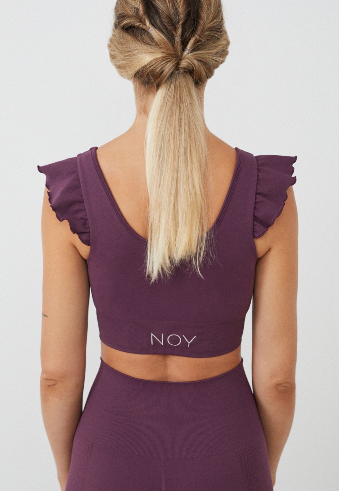 Vista trasera top yoga mujer marca NOY (not only yoga) modelo AINE con volantes tono cereza pansy plum