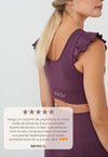 Vista lateral top yoga mujer marca NOY (not only yoga) modelo AINE con volantes tono cereza pansy plum