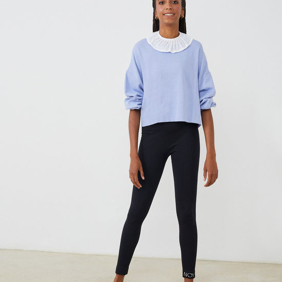 Sudadera mujer con CUELLO independiente tipo volante  NOY (not only yoga) modelo Chlöe de algodón orgánico blanco atado con lazo en la parte trasera y combinado con legging negro y sandalias  negras