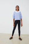 Sudadera mujer con CUELLO independiente tipo volante  NOY (not only yoga) modelo Chlöe de algodón orgánico blanco atado con lazo en la parte trasera y combinado con legging negro y sandalias  negras