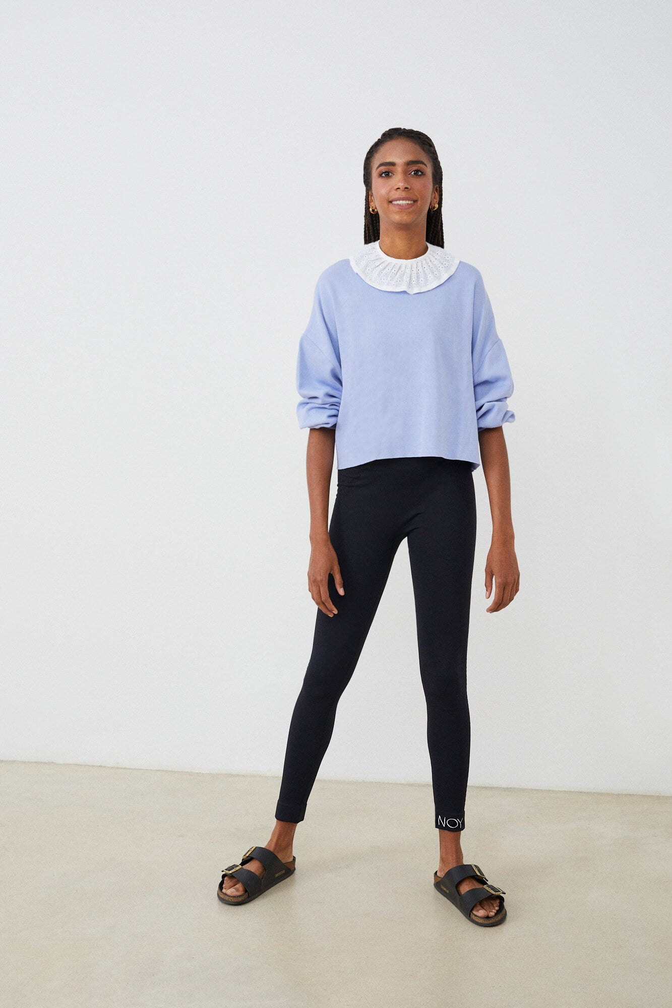 Sudadera mujer con CUELLO independiente tipo volante  NOY (not only yoga) modelo Chlöe de algodón orgánico blanco atado con lazo en la parte trasera y combinado con legging negro y sandalias  negras
