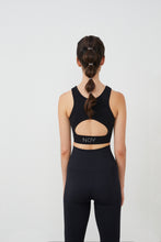 Cargar imagen en el visor de la galería, Vista trasera top yoga mujer marca NOY (not only yoga) modelo HERA con apertura bajo pecho y espalda tono negro black lava
