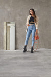 Top yoga mujer marca NOY (not only yoga) modelo HERA sin costuras tono negro black lava combinado con blazer beige vaqueros botas y bolso naranja