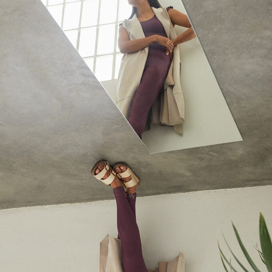 Conjunto yoga mujer marca NOY (not only yoga) modelo GAIA y top AINE con volantes sin costuras tono cereza pansy plum combinado con chaleco nude y sandalias metalizadas