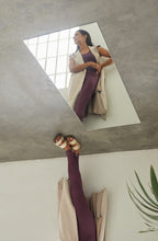 Cargar imagen en el visor de la galería, Conjunto yoga mujer marca NOY (not only yoga) modelo GAIA y top AINE con volantes sin costuras tono cereza pansy plum combinado con chaleco nude y sandalias metalizadas
